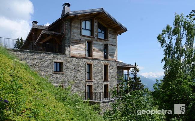 Chalet located in a scenic spot, with manufactured stone cladding by Geopietra and wooden facades, surrounded by vegetation